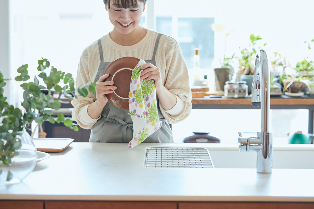 Woman holding fresh Shirayuki cloth in bright kitchen